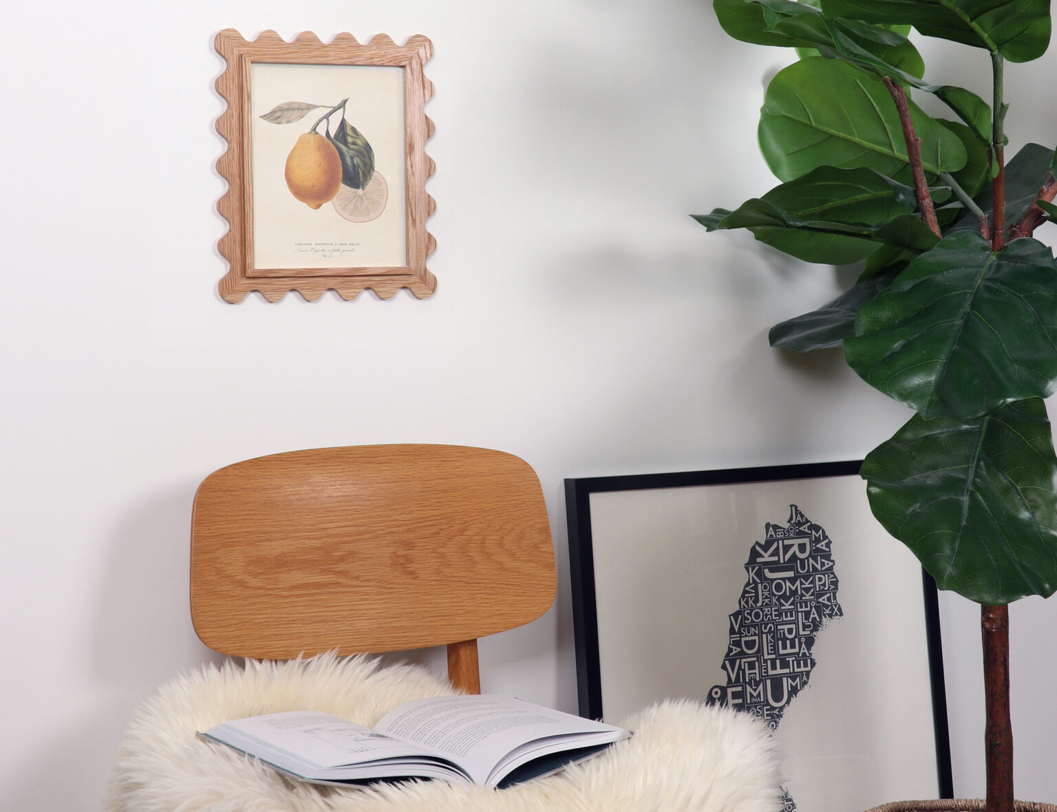 8x10 scalloped picture frame in white oak with a lemon print, hung above a wooden chair