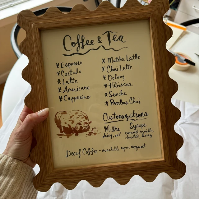 Customer photo of a white oak Elise scallop frame holding a menu